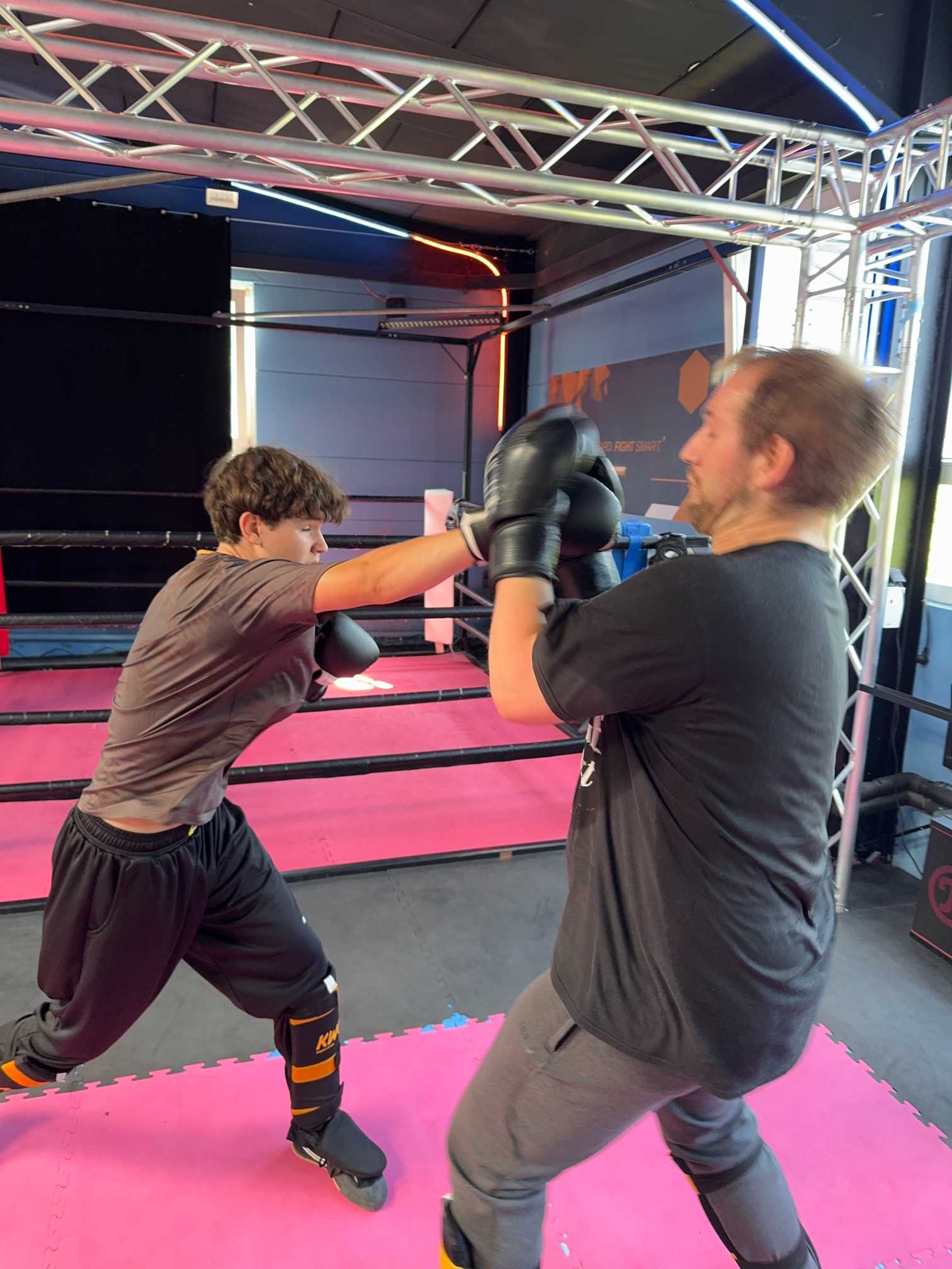 Zwei Sportler beim Kickbox‑Sparring im Trainingsring der LKF Academy in Solingen, mit Schutzausrüstung und kontrollierter Technik.
